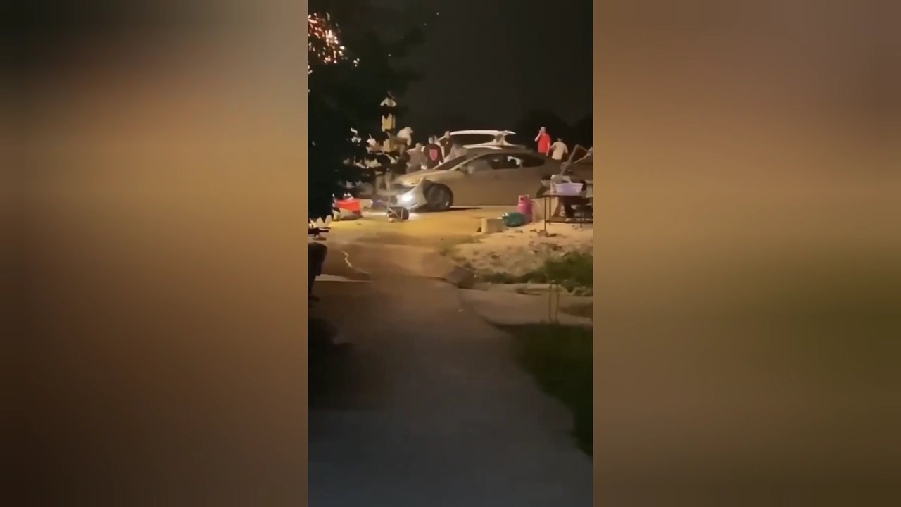 Tài xế ô tô liên tục tiến - lùi giữa vòng vây của hàng chục người. Ảnh cắt từ clip