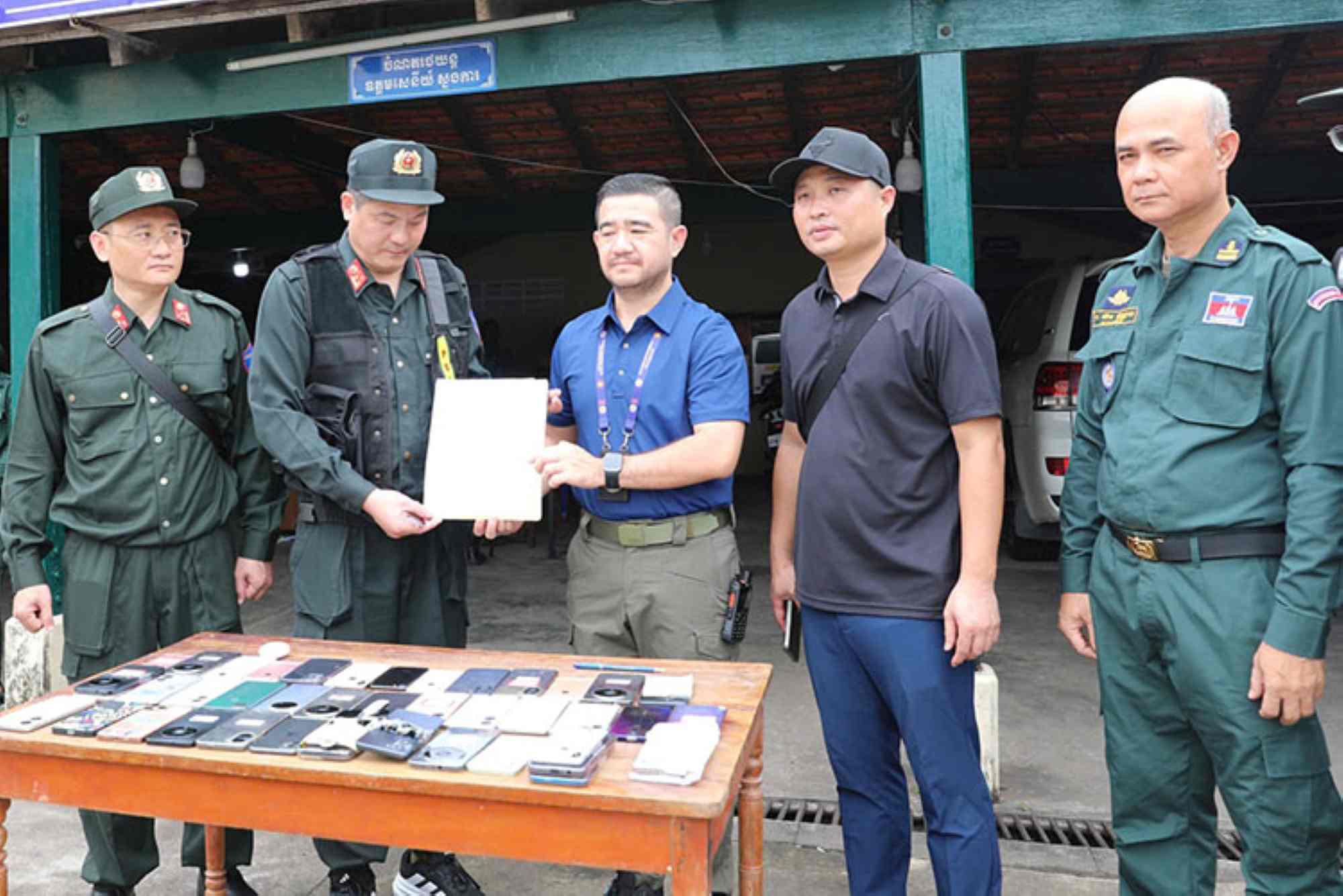 Lực lượng chức năng Campuchia bàn giao danh sách, tang vật lừa đảo cho Cơ quan Cảnh sát điều tra Công an Việt Nam. Ảnh: Công an Lai Châu