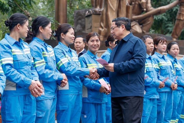 Thủ tướng thăm và động viên công nhân môi trường đô thị đang thực hiện nhiệm vụ tại phố Trần Nhân Tông - Ảnh: VGP/Nhật Bắc