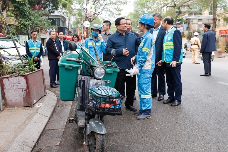 Thủ tướng thăm và động viên công nhân môi trường đô thị đang thực hiện nhiệm vụ tại phố Nguyễn Thái Học - Ảnh: VGP/Nhật Bắc