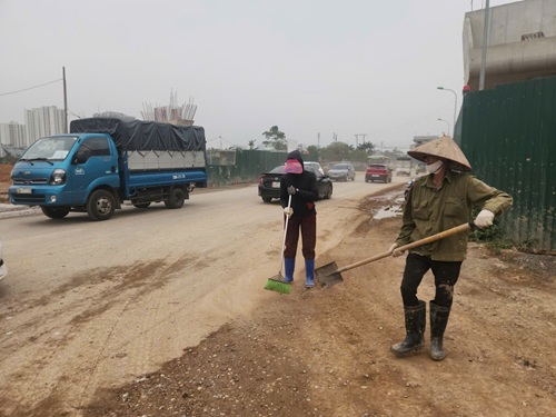 Mặc dù đơn vị thi công đã bố trí nhân công thu dọn nhưng đất đá vẫn tràn ra mặt đường. Ảnh: Minh Hạnh