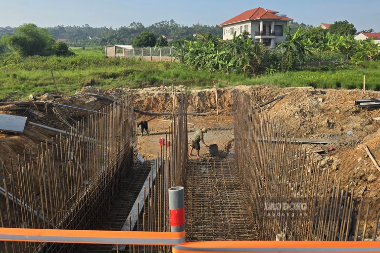 Các công nhân đang thi công một công trình thoát nước ngang đường. Ảnh: Tô Công