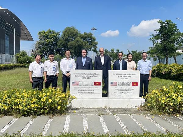 Đại sứ Hoa Kỳ tại Việt Nam Marc E.Knapper và đoàn công tác chụp ảnh lưu niệm với lãnh đạo Cảng HKQT Đà Nẵng tại bBia đá ghi nhớ Dự án xử lý môi trường ô nhiễm Dioxin sân bay Đà Nẵng