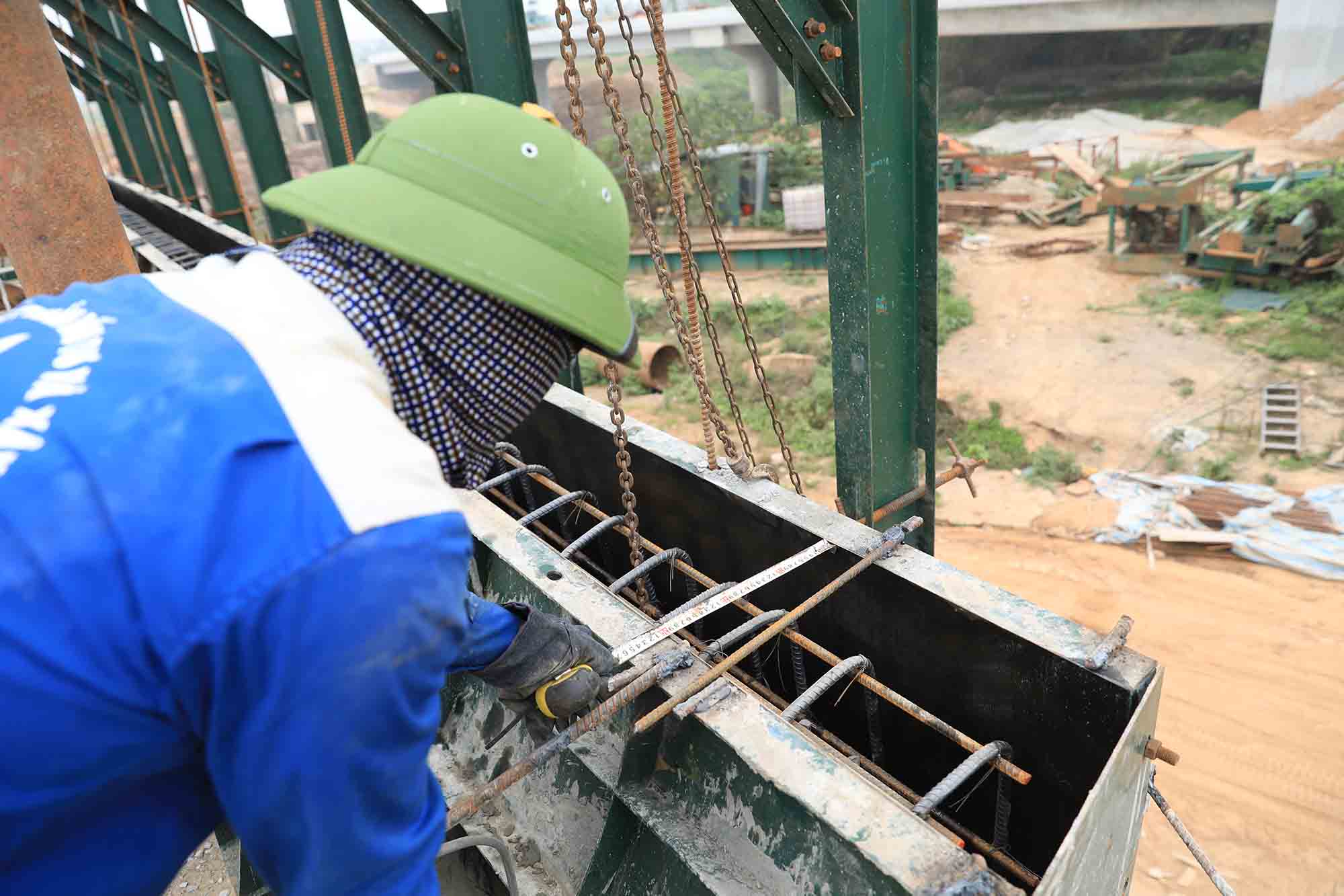 Công nhân đang thi công hạng mục lan can cầu vượt sông Cà Lồ. Ảnh: Hữu Chánh