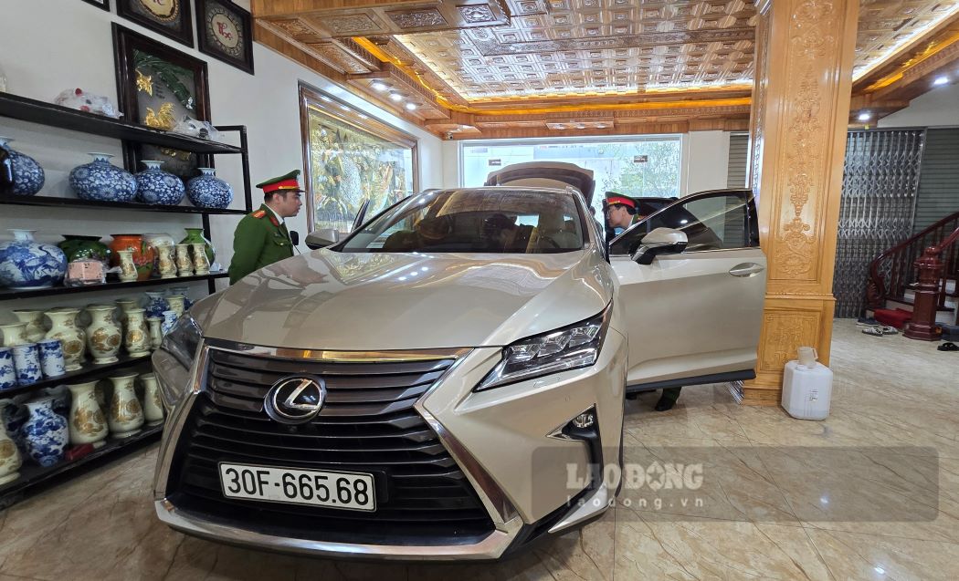 Hai chiếc xe ô tô hạng sang mà cơ quan điều tra đã thu giữ, quản lý sau khi khám xét khẩn cấp nơi ở của “Tuấn chợ Gốc“. Ảnh: Nam Hồng