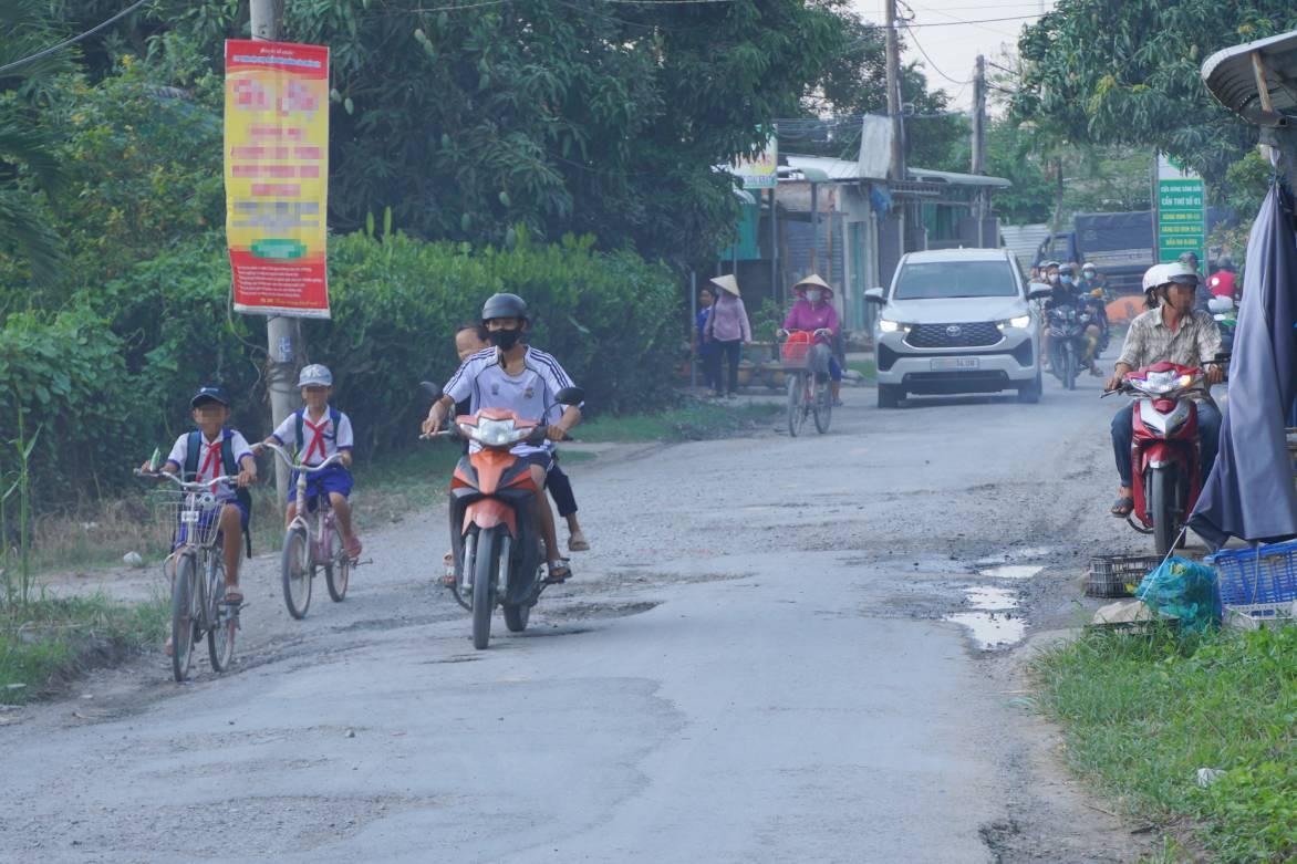 Học sinh đi lại trên con đường xuống cấp. Ảnh: Tạ Quang