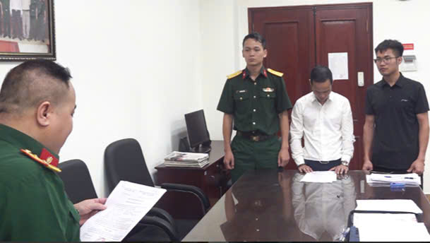 Điều tra viên Viện kiểm sát quân sự trung ương tống đạt quyết định khởi tố bị can đối với Tạ Quang Minh. (Ảnh: VKSQS)