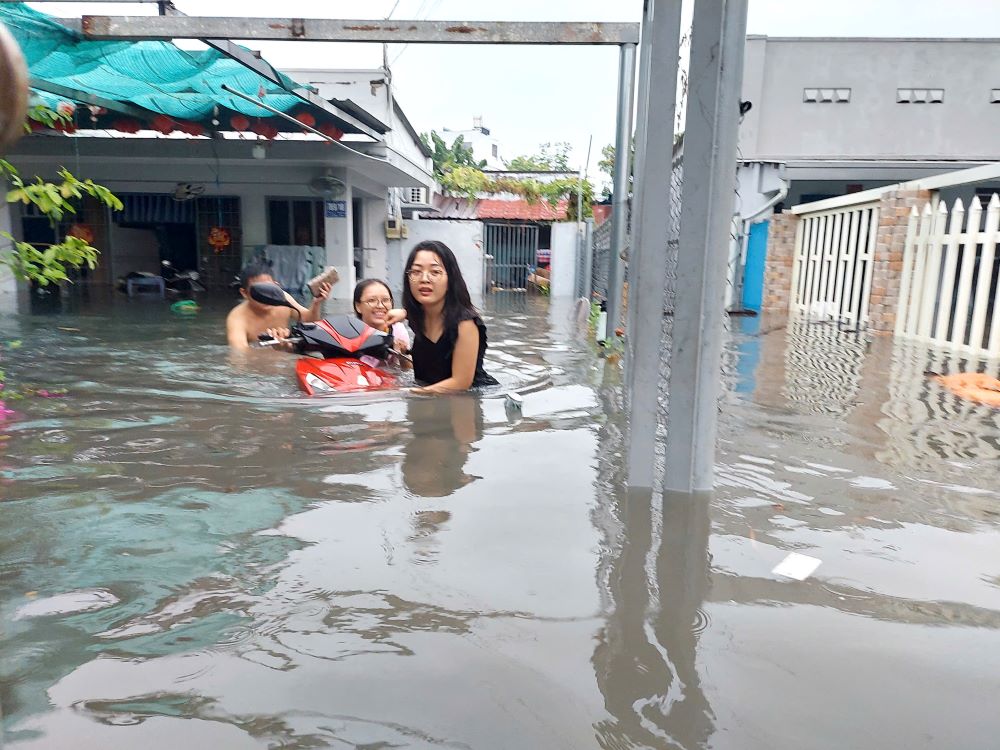 Mưa lớn sáng 10.5 khiến hẻm 789 Tỉnh lộ 43 (phường Tam Bình, TP Thủ Đức) ngập sâu, người dân phải tất bật di chuyển đồ đạc ra ngoài. Ảnh: Minh Quân