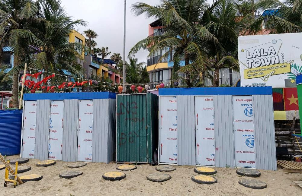 Những khu tắm tráng (tắm nước ngọt) được quây tôn trên bãi cát trông tạm bợ và có phần nhếch nhác. Ảnh: Quách Du
