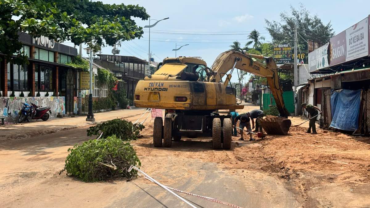 Nhiều lực lượng khắc phục cát tràn xuống đường du lịch. Ảnh: Duy Tuấn
