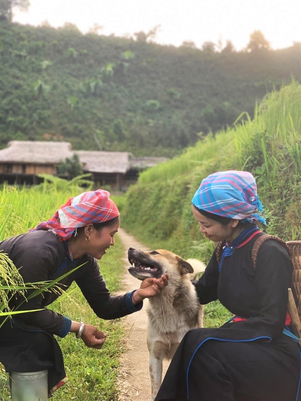Chị Vàng Thị Thông (trái), chủ homestay ở Bản Liền cũng là chủ nhà trong chương trình Gia đình Haha, cùng chú chó Gấu thân thiện đón khách. Ảnh: Đỗ Phúc
