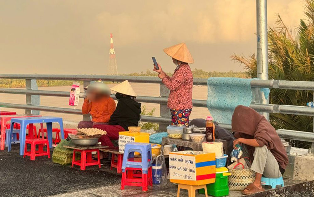 Người dân bày bán đủ loại thức ăn trên cầu Đại Ngãi 2. Ảnh: Phương Anh