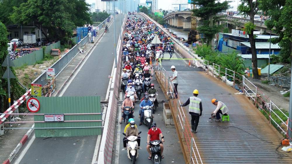 Công nhân lắp đặt cầu tạm bằng thép tại đầu cầu Bình Triệu 1. Ảnh: Anh Tú