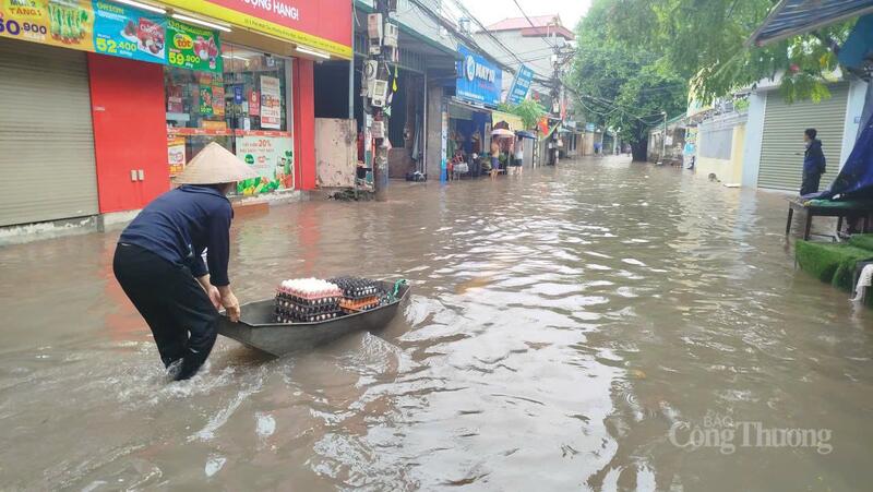 Người dân dùng thuyền vận chuyển thực phẩm vào khu chăm sóc người cao tuổi Hà Nội trên phố Nhật Tảo, phường Phú Thượng, TP. Hà Nội. Ảnh: Hải Sơn