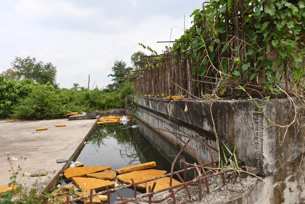 Mặt cầu ngổn ngang vật liệu xây dựng, nước đọng thành vũng. Ảnh: Anh Tú