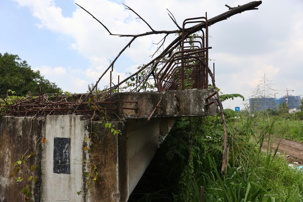 Xung quanh công trình rác thải vứt bừa bãi, cây dại phủ kín, và kết cấu sắt thép có dấu hiệu hoen rỉ. Ảnh: Anh Tú