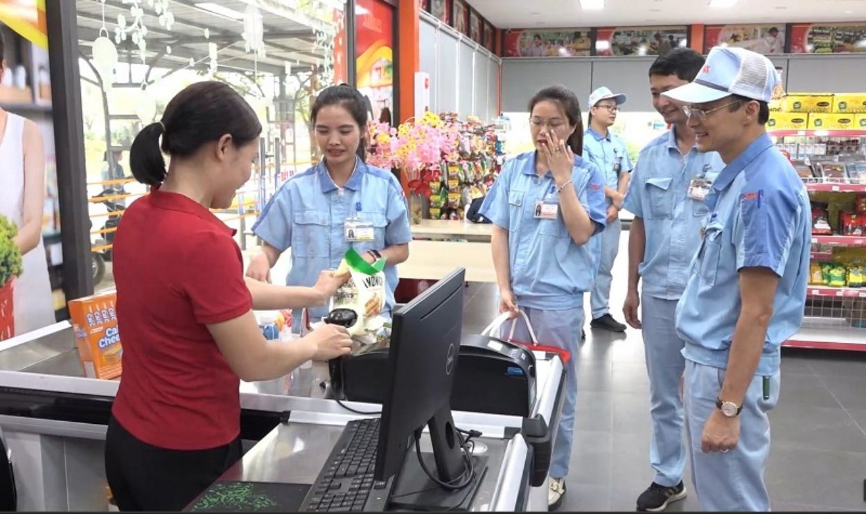 Chủ tịch Công đoàn Công ty TNHH Điện Stanley Việt Nam Ngô Ngọc Vinh (ngoài cùng bên phải) và công nhân mua hàng tại Siêu thị Công đoàn của công ty. Ảnh: Ngọc Ánh