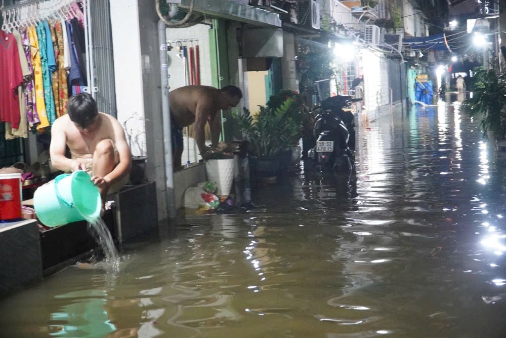 Người dân cư xá Thanh Đa dùng xô chậu, máy bơm tát nước xuyên đêm để chống ngập. Ảnh: Thái Bảo
