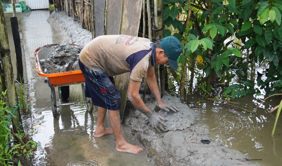 Người dân tích cực gia cố bờ bao tạm để ngăn nước tràn vào nhà. Ảnh: Phương Anh