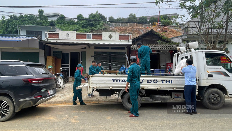 Lực lượng chức năng phường Cam Đường, tỉnh Lào Cai hỗ trợ người dân di dời tài sản và đặt biển cảnh báo. Ảnh: Đinh Đại