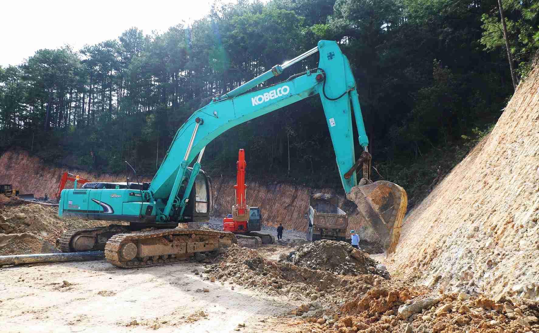 Máy múc hoạt động gia cố bờ taluy dương khu vực mở đường tạm qua điểm sạt lở trên đèo Mimosa. Ảnh: Phúc Khánh