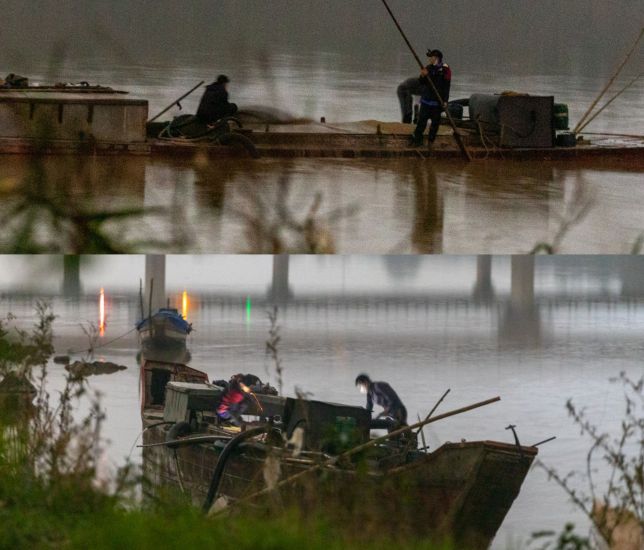 Lúc 23h55 đêm 1.12, chiếc tàu đến thôn Ngũ Hiệp hút đầy cát (ảnh trên) và bị chìm phần thân xuống dưới. Đến 1h30 ngày 2.12, chiếc tàu bơm hết cát lên bãi và nổi lên, người đeo khẩu trang ở trên tàu phụ trách việc bơm cát. Ảnh: PV