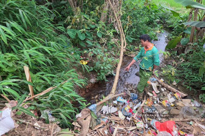 Người dân bức xúc chỉ dòng nước đen ô nhiễm chảy qua con suối nhỏ, dẫn thẳng ra khu vực đồng ruộng canh tác. Ảnh: Duy Dũng