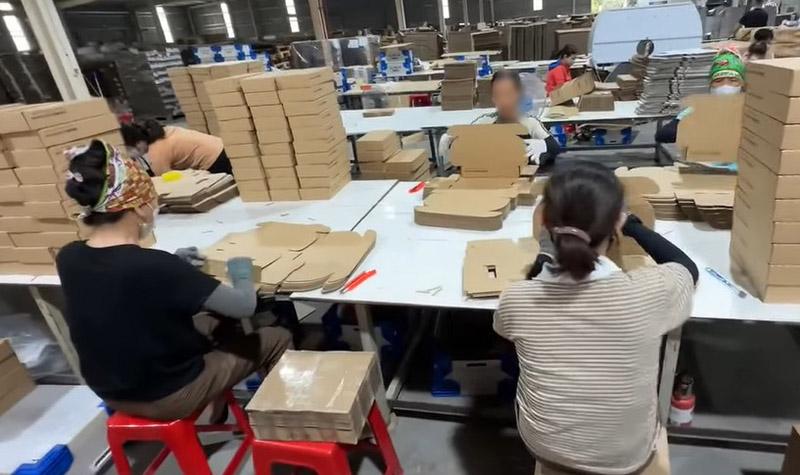 Bà Phương (áo đen) cùng công nhân tăng ca làm việc buổi tối. Ảnh: Minh Hương.