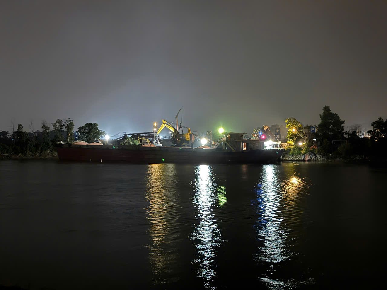 Ánh đèn tại bãi than hoạt động về đêm, theo người dân là thời điểm phát sinh nhiều bụi nhất. Ảnh: Mai Hương