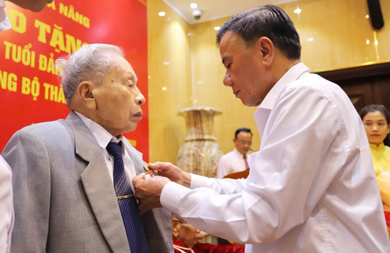 Thường trực Ban Bí thư Trần Cẩm Tú trao Huy hiệu 80 năm tuổi Đảng tặng đảng viên lão thành Trần Thanh Dân.