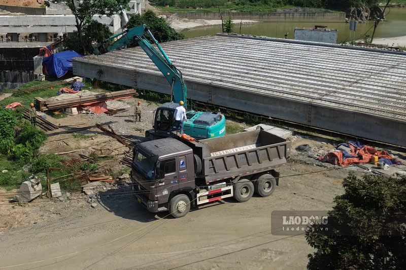 Công nhân cùng máy móc vận chuyển vận liệu phục vụ cho việc thi công. Ảnh: Đinh Đại
