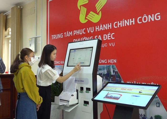 Công chức phường Sa Đéc (Đồng Tháp) hướng dẫn người dân nộp hồ sơ trực tuyến tại ki-ốt thông minh. Ảnh: Cổng TTĐT tỉnh Đồng Tháp