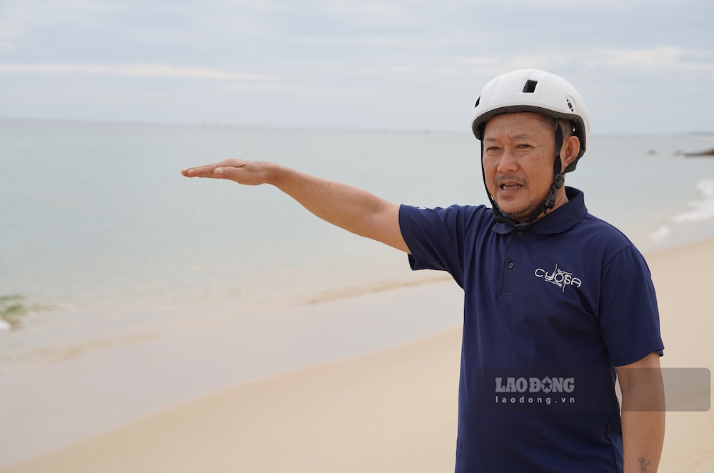 Ông Trần Ngọc Hà diễn tả độ cao của bãi cát những năm trước. Ảnh: Nguyễn Luân