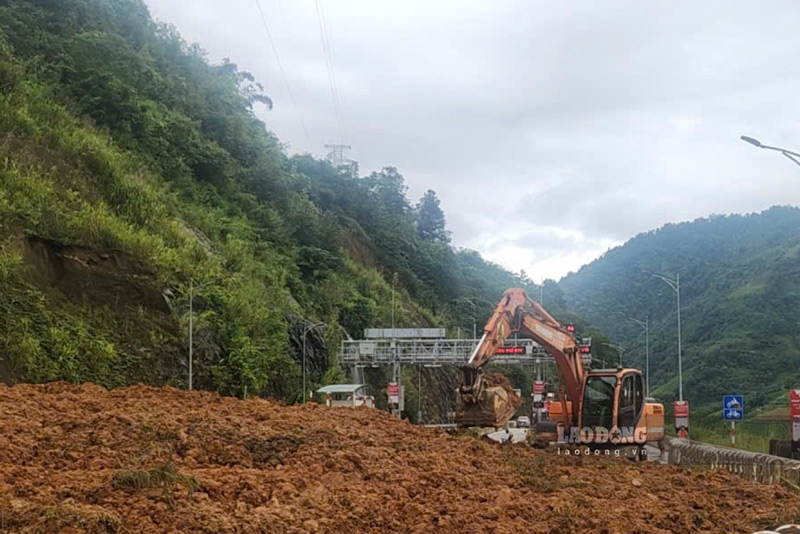 Máy móc được huy động khẩn trương hót dọn đất đá, khắc phục điểm sạt lở. Ảnh: Đinh Đại